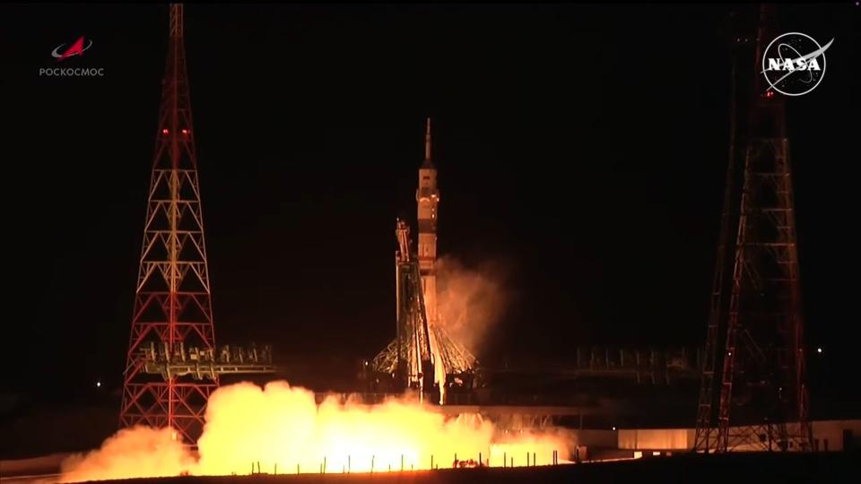  A rocket lifts off at night above a bright plume of fire. 