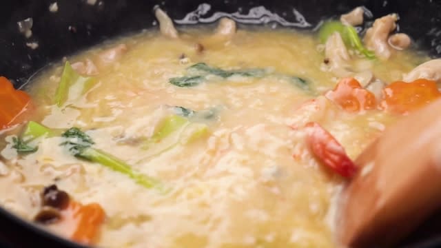 Stirring seafood gravy with a wooden spatula