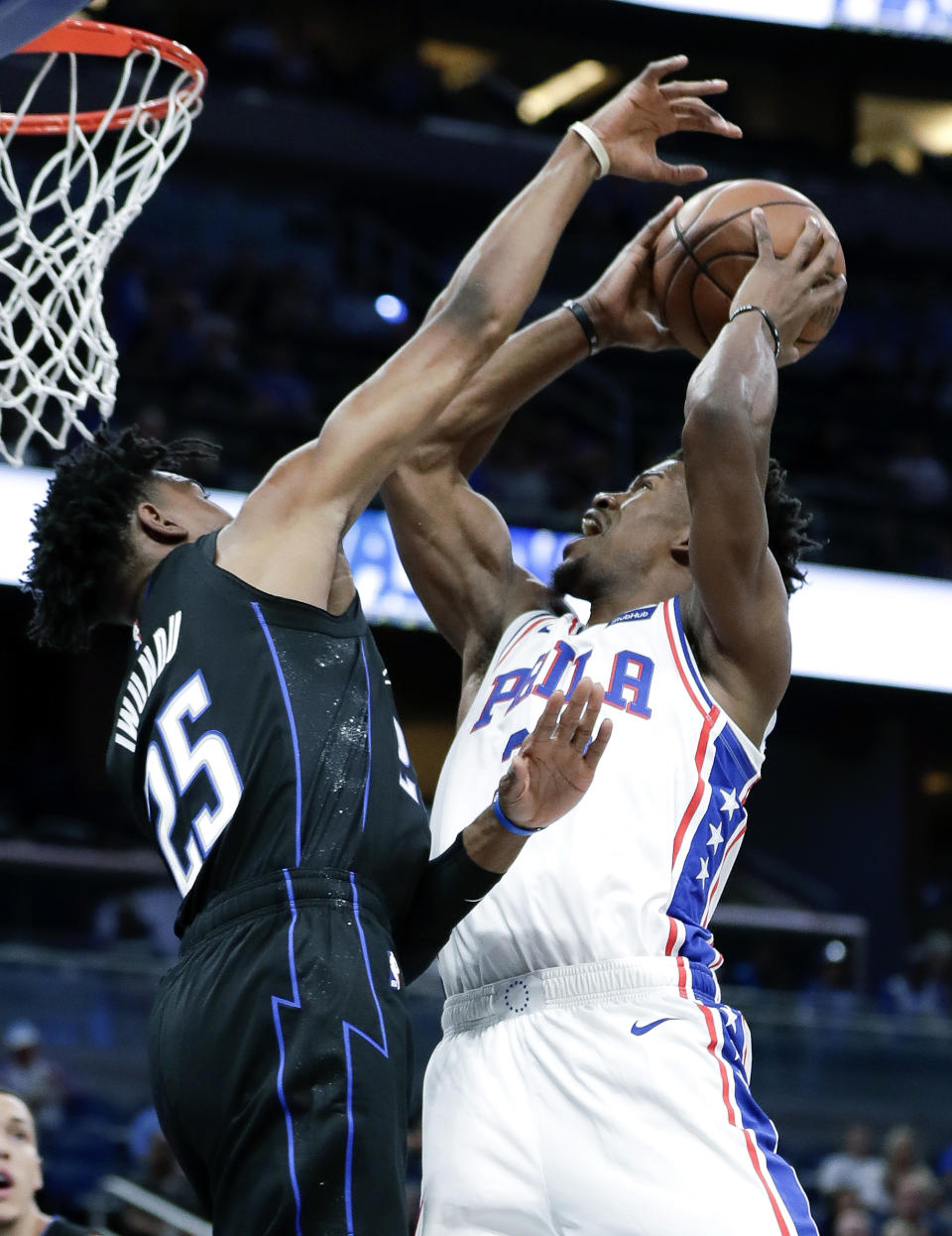 Philadelphia 76ers' Jimmy Butler, right, makes a shot against Orlando Magic's Wesley Iwundu (25) during the first half of an NBA basketball game Wednesday, Nov. 14, 2018, in Orlando, Fla. (AP Photo/John Raoux)
