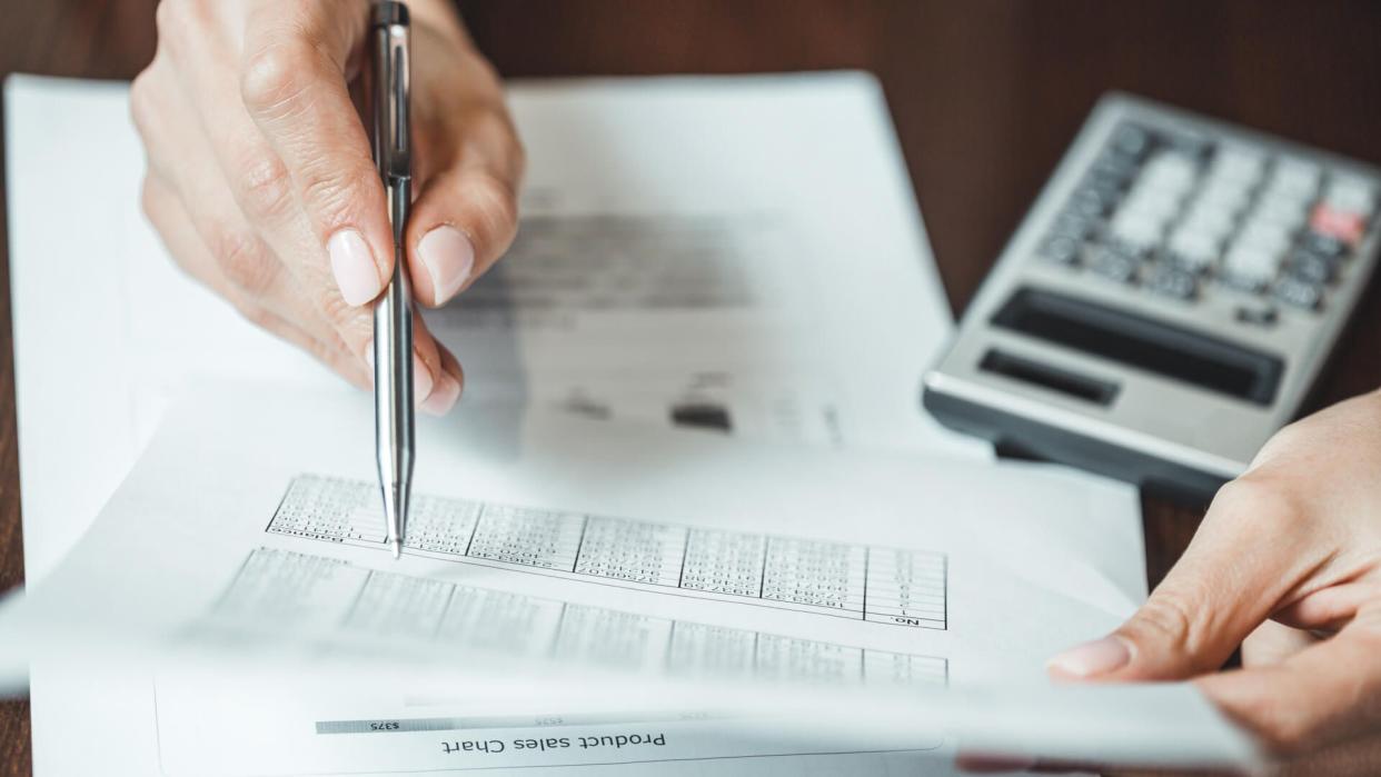 Close up of businesswomans hand with pen doing some financial calculations.