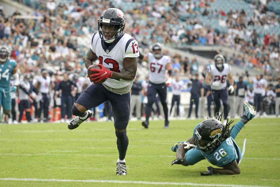 Houston Texans wide receiver Brandin Cooks (13) runs past Jacksonville Jaguars cornerback Shaquill Griffin (26) for a touchdown after a 22-yard reception during the first half of an NFL football game, Sunday, Dec. 19, 2021, in Jacksonville, Fla. (AP Photo/Phelan M. Ebenhack)