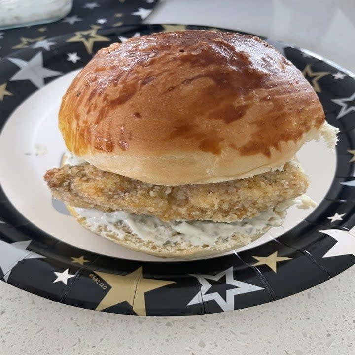 A chicken sandwich on a paper plate