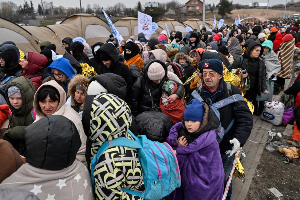 TOPSHOT - Refugees stand in line in the cold as they wait to be transferred to a train station after crossing the Ukrainian border into Poland, at the Medyka border crossing in Poland, on March 7, 2022. - More than 1.5 million people have fled Ukraine since the start of the Russian invasion, according to the latest UN data on March 6, 2022. (Photo by Louisa GOULIAMAKI / AFP) (Photo by LOUISA GOULIAMAKI/AFP via Getty Images)