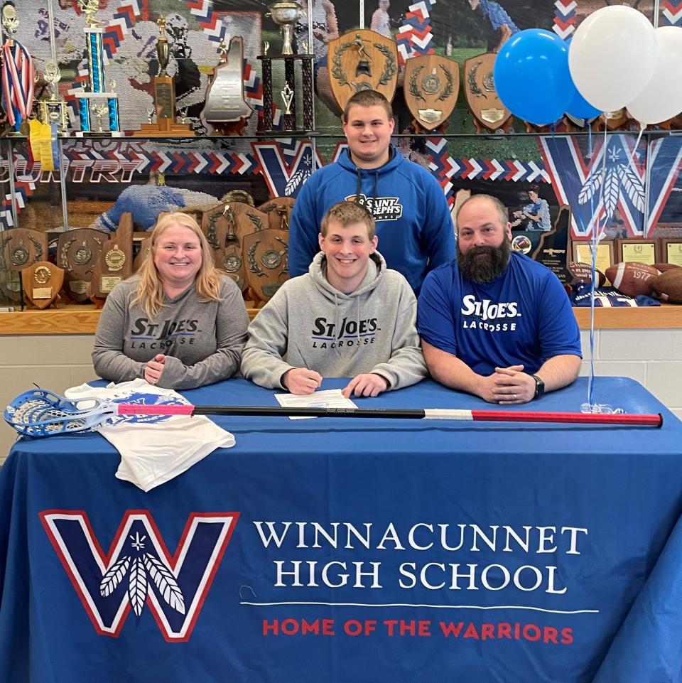 Winnacunnet senior Jake Magri, front center, is joined by his mom, Maura; dad, Steve; and brother, Anthony, after announcing he will continue his academics and play men's lacrosse next year at Saint Joseph's College in Standish, Maine.