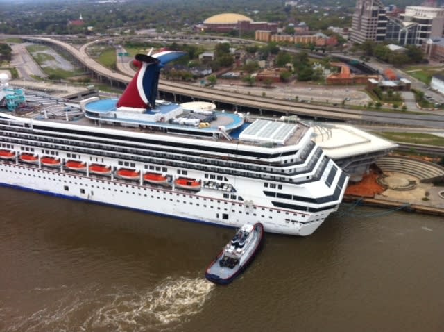 A tug vessel pushes the Carnival Triumph to moor at the Signal International shipyard on the Mobile River, April 3, 2013. The cruise ship broke loose from a BAE Systems dry dock after strong winds from a storm. (U.S. Coast Guard photo)