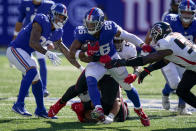 New York Giants running back Saquon Barkley (26) runs the ball past Atlanta Falcons linebacker Foye Oluokun, right, during the second half of an NFL football game, Sunday, Sept. 26, 2021, in East Rutherford, N.J. (AP Photo/Seth Wenig)