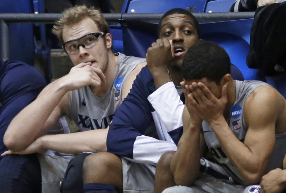 Xavier players, left to right, Matt Stainbrook, James Farr, and Dee Davis sit on the bench in the closing minute of the team's 74-59 loss to North Carolina State in a first-round game of the NCAA college basketball tournament, Tuesday, March 18, 2014, in Dayton, Ohio. (AP Photo/Al Behrman)