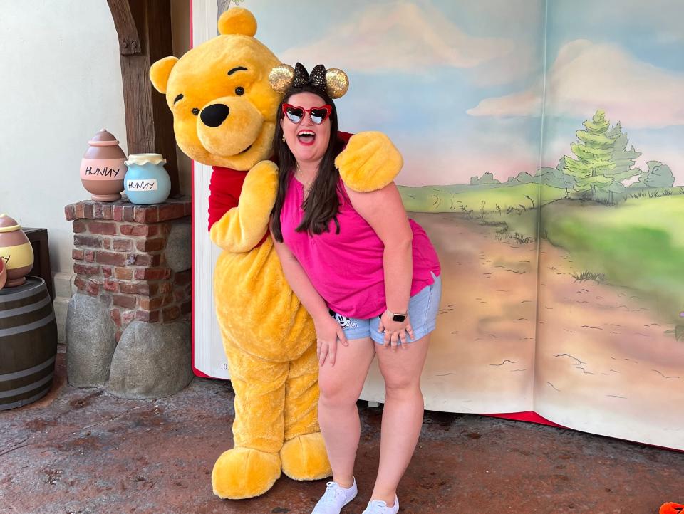 megan posing with pooh bear at disney world as an adult