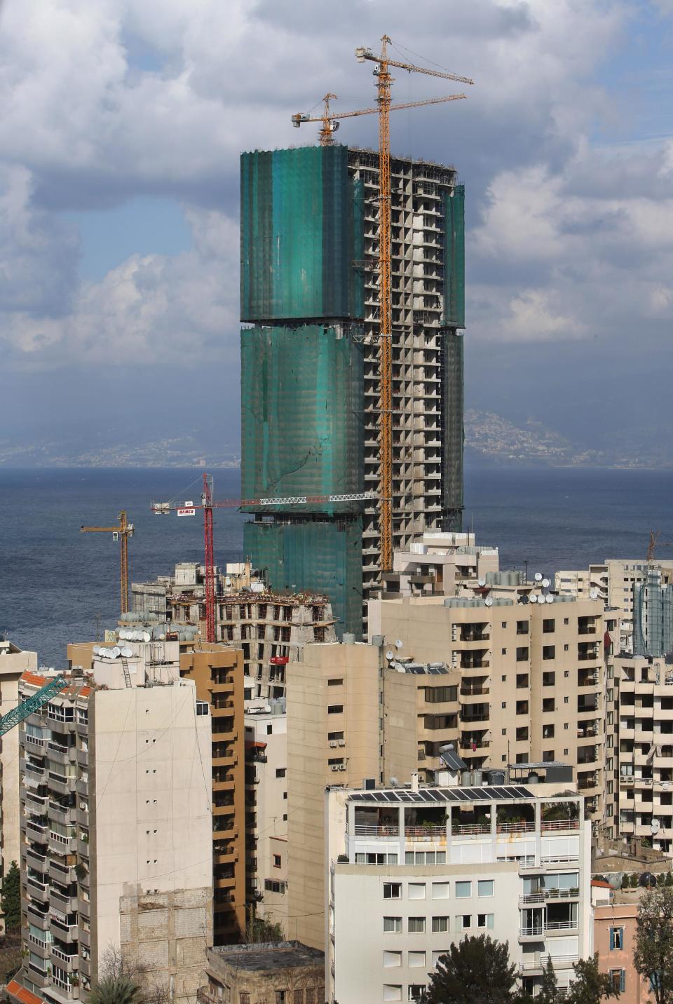 In this February 18, 2014 photo, a luxury tower, center, is under construction on the seafront, in Beirut, Lebanon. A famously scenic Mediterranean city surrounded by once lush mountains, Beirut may soon be overrun with buildings -- all at the expense of green parks and pedestrian areas. While Lebanon's real estate sector has developed to become one of the country's success stories, many say it is coming at the expense of Lebanon's identity and heritage.(AP Photo/Hussein Malla)