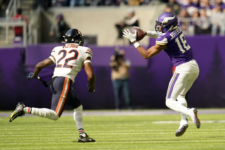 Minnesota Vikings wide receiver Justin Jefferson (18) catches a pass ahead of Chicago Bears cornerback Kindle Vildor (22) during the first half of an NFL football game, Sunday, Oct. 9, 2022, in Minneapolis. (AP Photo/Abbie Parr)