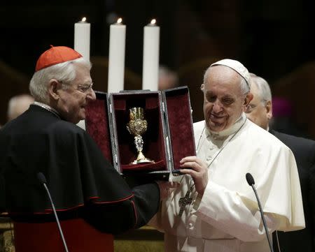 Cardinal Angelo Scola, the Archbishop of Milan, presents a chalice to Pope Francis during a meeting with priests and consecrated persons at the Duomo, the cathedral of Milan, in Milan, Italy, March 25, 2017. REUTERS/Max Rossi