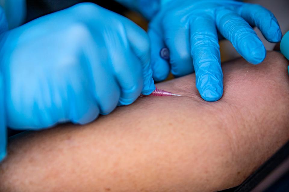 Registered nurse Salah Hadwan infuses patient Rebecca Ivey, 54, of Battle Creek, with monoclonal antibody treatment at Wayne Health Detroit Mack Health Center in Detroit on Dec. 10, 2021.