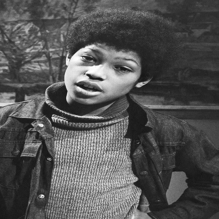 him as a kid in the role, wearing a denim jacket with an Afro