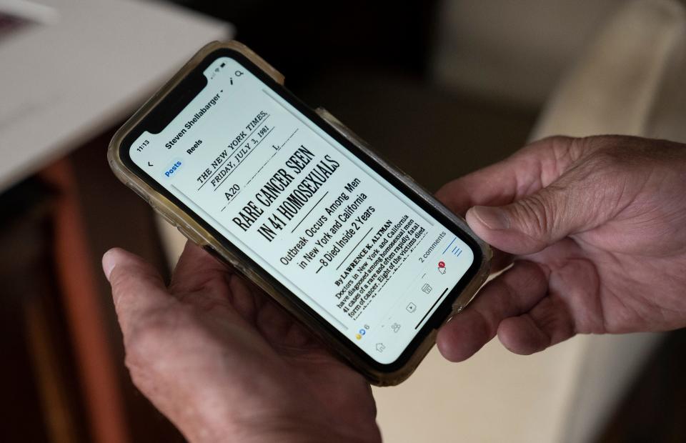 Steve Shellabarger holds his phone to show a New York Times headline from 1981 that reads, "Rare Cancer Seen in 41 Homosexuals." The story refers to the first cases of AIDS that were discovered in New York and California.