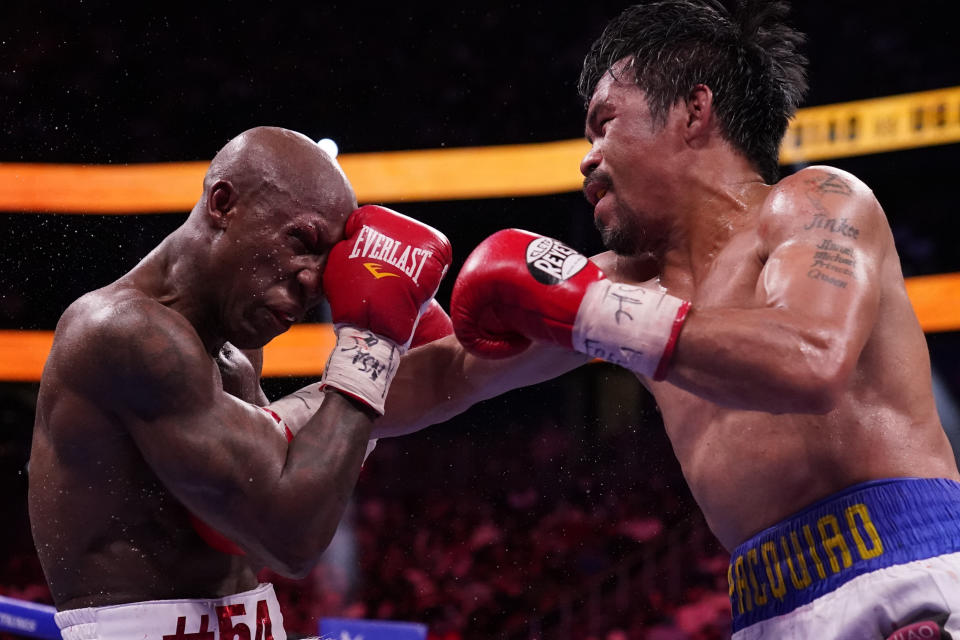 Manny Pacquiao, right, of the Philippines, hits Yordenis Ugas, of Cuba, in a welterweight championship boxing match Saturday, Aug. 21, 2021, in Las Vegas. (AP Photo/John Locher)