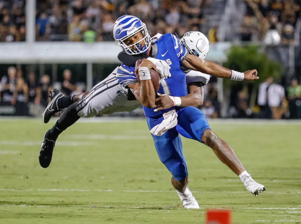 Oct 22, 2021; Orlando, Florida, USA; Memphis Tigers quarterback Peter Parrish (1) is tackled by UCF Knights defensive lineman Tre'mon Morris-Brash (33) during the second half at Bounce House. Mandatory Credit: Mike Watters-USA TODAY Sports