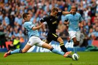 Wigan Athletic's striker Callum McManaman (R) dribbles the ball through the stretching challenge of Manchester City's defender Matija Nastasic during the English FA Cup final at Wembley Stadium in London on May 11, 2013. Wigan won 1-0