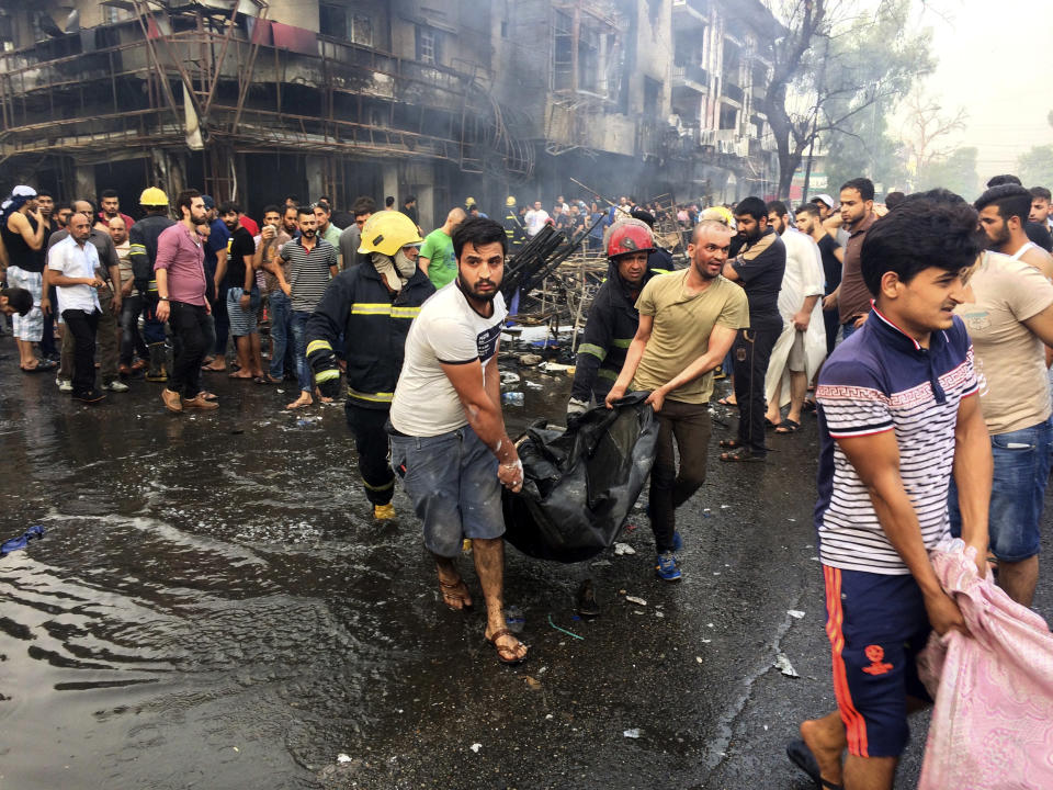 FILE - In this July 3, 2016 file photo, Iraqi firefighters and civilians carry bodies of people killed in a car bomb at a commercial area in Karada neighborhood, Baghdad, Iraq. Ten years ago, an uprising in Tunisia opened the way for a wave of popular revolts against authoritarian rulers across the Middle East known as the Arab Spring. For a brief window as leaders fell, it seemed the move toward greater democracy was irreversible. Instead, the region saw its most destructive decade of the modern era. Syria, Yemen, Libya and Iraq have been torn apart by wars, displacement and humanitarian crisis. (AP Photo/Khalid Mohammed, File)