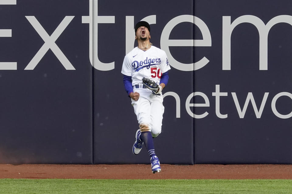 Los Angeles Dodgers right fielder Mookie Betts celebrates after robbing Atlanta Braves' Marcell Ozuna of a home during the fifth inning in Game 6 of a baseball National League Championship Series Saturday, Oct. 17, 2020, in Arlington, Texas. (AP Photo/Tony Gutierrez)