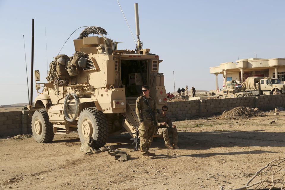 FILE - In this Feb. 23, 2017 file photo, U.S. Army soldiers stand outside their armored vehicle on a joint base with the Iraqi army, south of Mosul, Iraq. As Iraqi forces push into western Mosul coalition troops are closer to frontline fighting than ever before. The Iraqi government has told its military not to seek assistance from the U.S.-led coalition forces in operations against the Islamic State group, two senior Iraqi military officials said. The move comes amid a crisis of mistrust tainting U.S.-Iraq ties after an American strike killed Soleimani and an Iraqi militia commander. (AP Photo/ Khalid Mohammed, File)