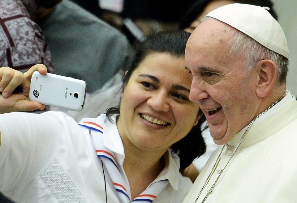 Pope Francis takes a selfie with a woman during a meeting with the Youth Eucharistic Movement in the Paul VI hall at the Vatican on August 7, 2015. AFP PHOTO / FILIPPO MONTEFORTE        (Photo credit should read FILIPPO MONTEFORTE/AFP/Getty Images)