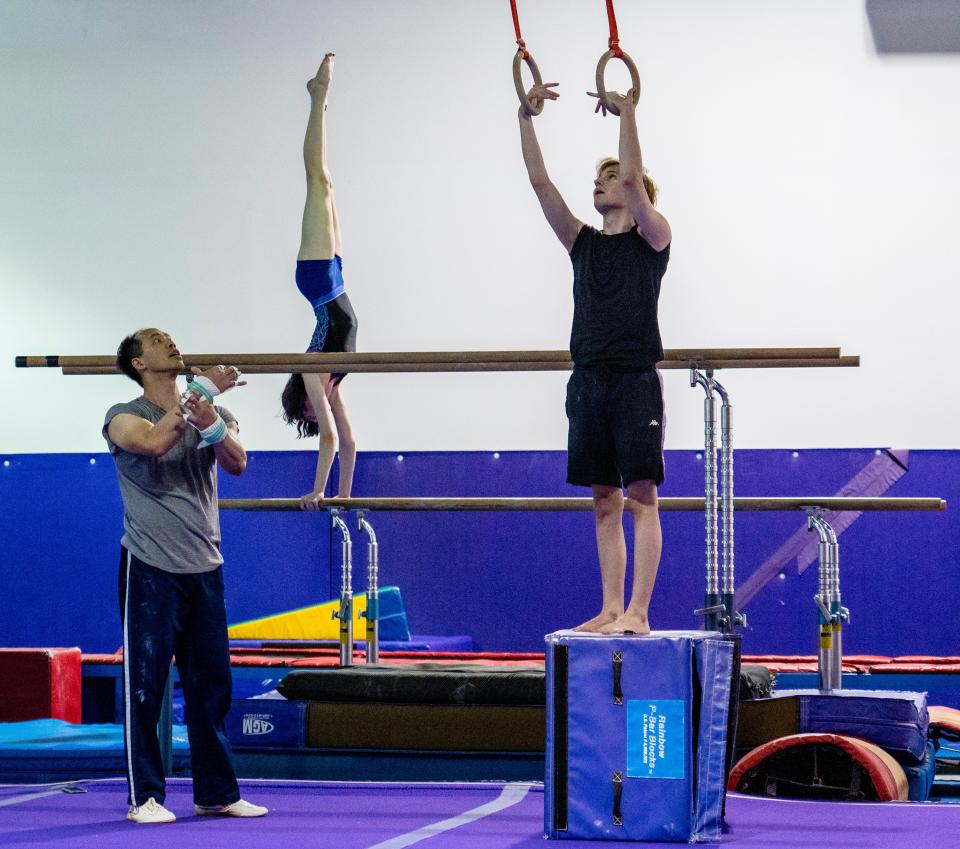 (Left to right) Ray Wu, Maya Barron and Ryan Cardwell practice gymnastics at the weekly adult gymnastics class at Wildcard Gymnastics in Brookfield on Wednesday, July 20, 2022.