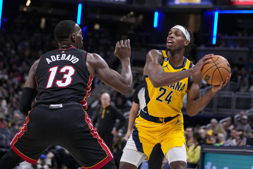 Indiana Pacers guard Buddy Hield (24) looks to pass over Miami Heat center Bam Adebayo (13) during the second half of an NBA basketball game in Indianapolis, Friday, Nov. 4, 2022. The Pacers defeated the Heat 101-99. (AP Photo/Michael Conroy)