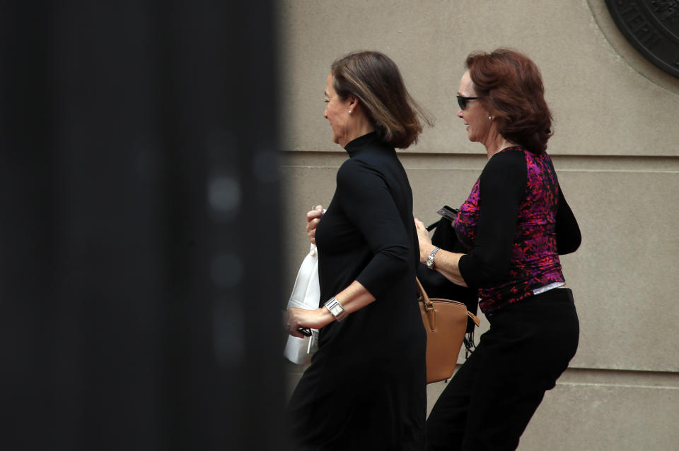 Kathleen Manafort, right, runs towards the entrance at teh Alexandria Federal Courthouse in Alexandria, Va., Friday, Aug. 3, 2018, after a noon break on her husband, President Donald Trump's former campaign chairman Paul Manafort's tax evasion and bank fraud trial. (AP Photo/Manuel Balce Ceneta)