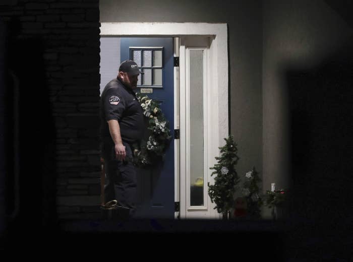 A law enforcement official stands at the front door of the home.