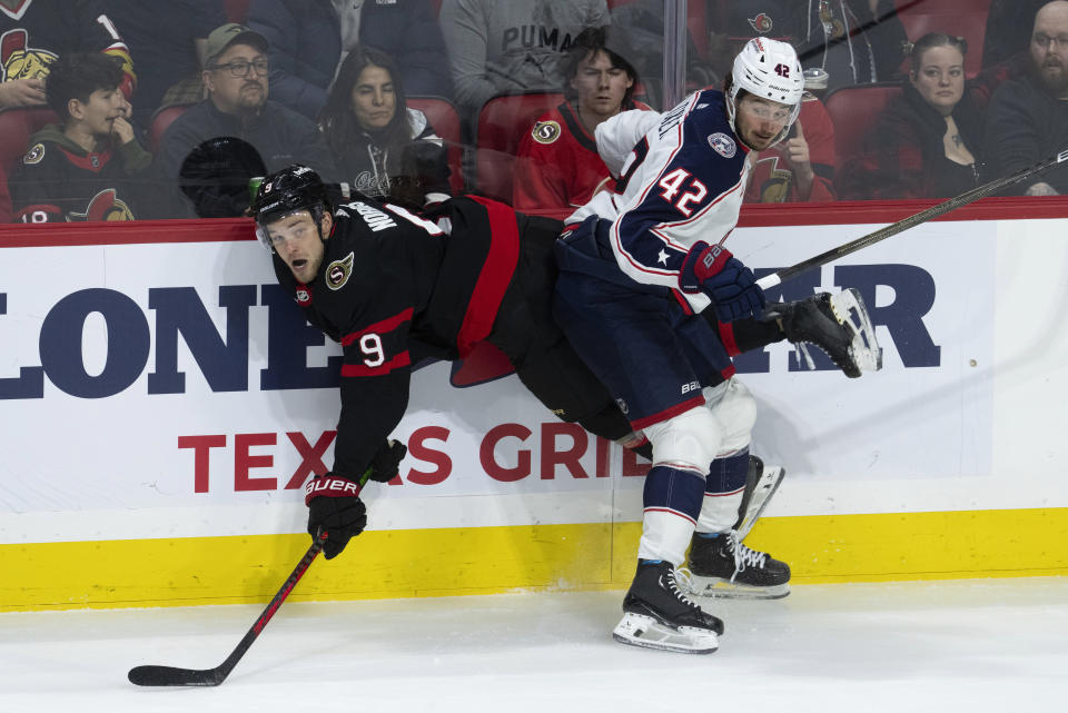 Columbus Blue Jackets center Alexandre Texier collides along the boards with Ottawa Senators center Josh Norris during the second period of an NHL hockey game, Tuesday, Feb. 13, 2024, in Ottawa, Ontario. (Adrian Wyld/The Canadian Press via AP)