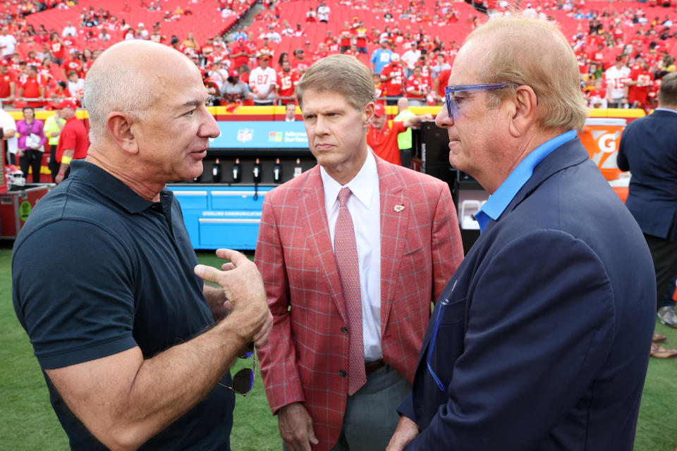 KANSAS CITY, MISSOURI - SEPTEMBER 15: (L-R) Former Amazon CEO Jeff Bezos talks with Kansas City Chiefs Owner Clark Hunt and Los Angeles Chargers Owner Dean Spanos on the field before the game at Arrowhead Stadium on September 15, 2022 in Kansas City, Missouri. (Photo by Jamie Squire/Getty Images)