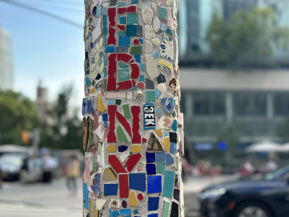 <p>A Portrait mode photo from the iPhone 14 Pro's main camera of colorful mosaic detail on a lamp post with a wider crop.</p>
