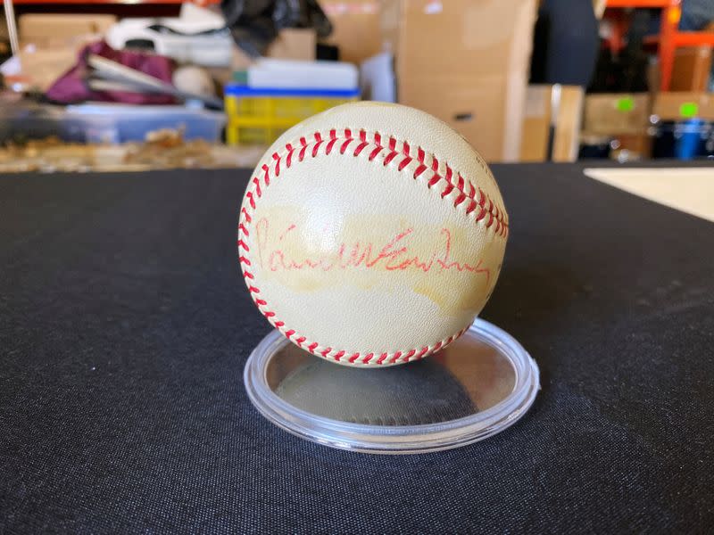 A baseball signed by all four members of The Beatles, with Paul McCartney's signature visible, is displayed in a Julien's Auctions warehouse in Torrence, California