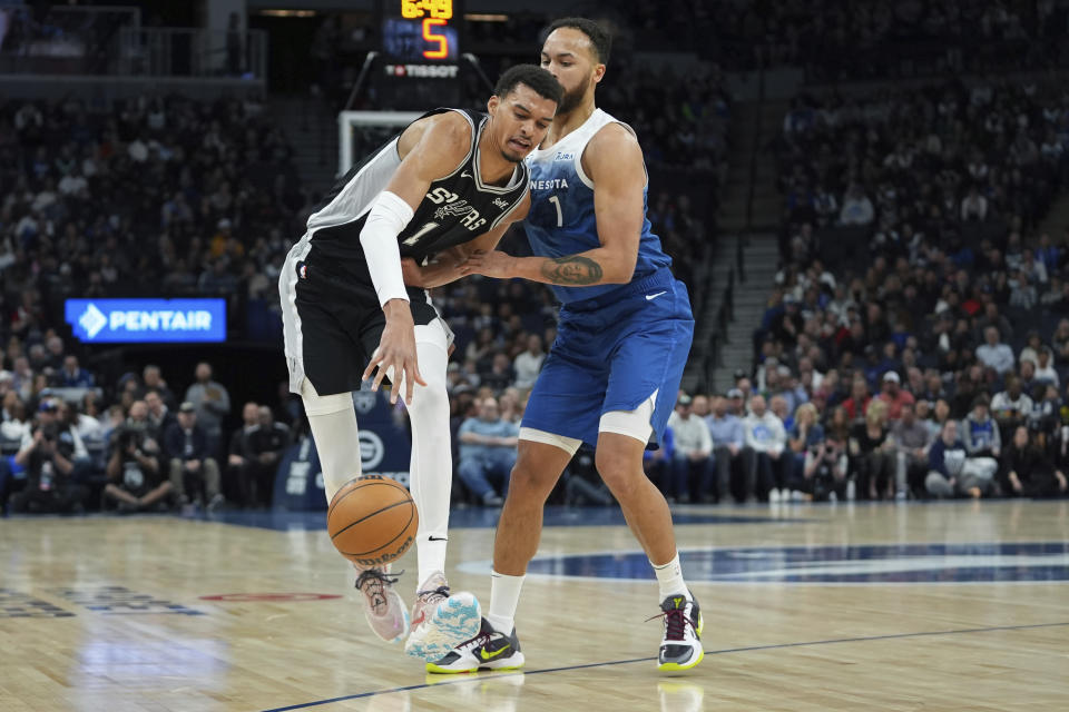 San Antonio Spurs center Victor Wembanyama, left, works toward the basket as Minnesota Timberwolves forward Kyle Anderson defends during the first half of an NBA basketball game Tuesday, Feb. 27, 2024, in Minneapolis. (AP Photo/Abbie Parr)