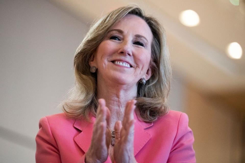 Barbara Comstock smiles and applauds.