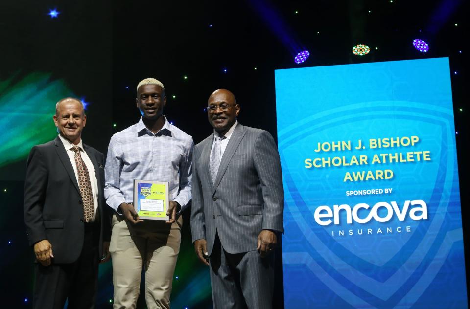 Gahanna Lincoln's Adolphus Addison receives his John J. Bishop Award from John Kessler, Encova Insurance executive vice president and chief strategy officer, and Archie Griffin, two-time Heisman Trophy winner and Encova Insurance representative.