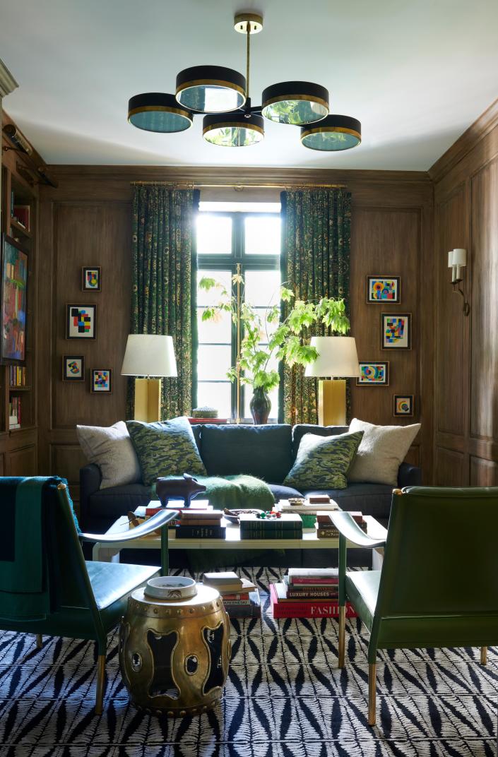 Jewel tones like emerald, gold, and sapphire are seen in this sitting area designed by Jessica Lagrange Interiors.