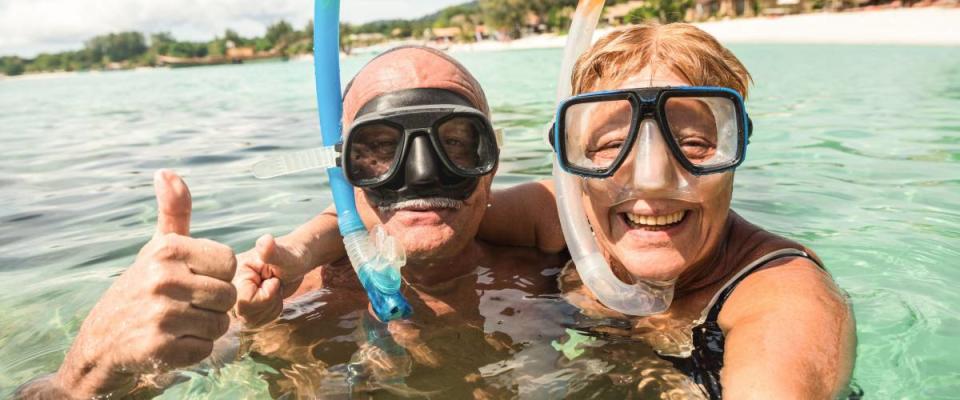 Senior happy couple taking selfie in tropical sea excursion with water camera