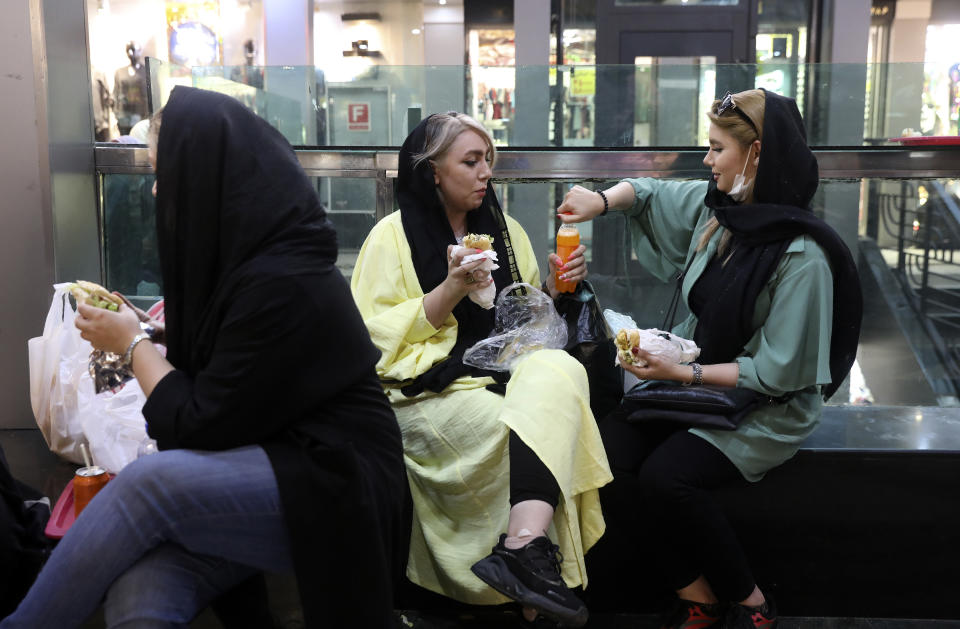 In this Wednesday, June 10, 2020, photo, people have their lunch in a shopping center at the Tehran's Grand Bazaar in Iran. As businesses open and people begin to move around more, health experts fear a growing complacency among Iran’s 80 million people may further allow the virus to spread. (AP Photo/Vahid Salemi)