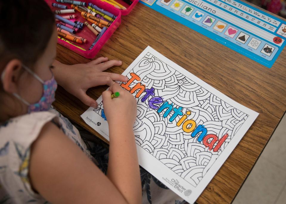 First-grader Ella Siciliano colors the word 'intentional' during a class at J.F. Burns Elementary on Aug. 31. The class was getting a session on the Character Effect, a social-emotional learning program that helps kids learn their own positive character traits and identify those of others. Beech Acres Parenting Center trains teachers in the program who then teach their students.