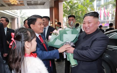 Kim Jong-un receives a bouquet of flowers as he arrives at the Melia hotel in Hanoi - Credit: KCNA/AFP