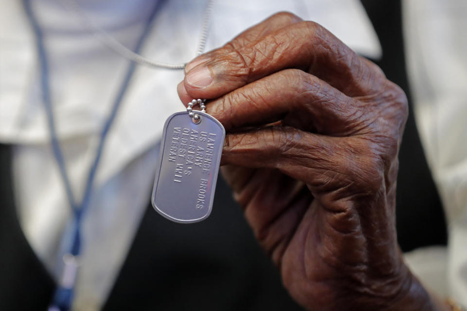 FILE -World War II veteran Lawrence Brooks holds a dog tag honoring him as the oldest living World War II veteran, as he celebrates his 110th birthday at the National World War II Museum in New Orleans, on Sept. 12, 2019. Brooks, the oldest World War II veteran in the U.S. — and believed to be the oldest man in the country — died on Wednesday, Jan. 5, ,2022 at the age of 112. (AP Photo/Gerald Herbert, File)