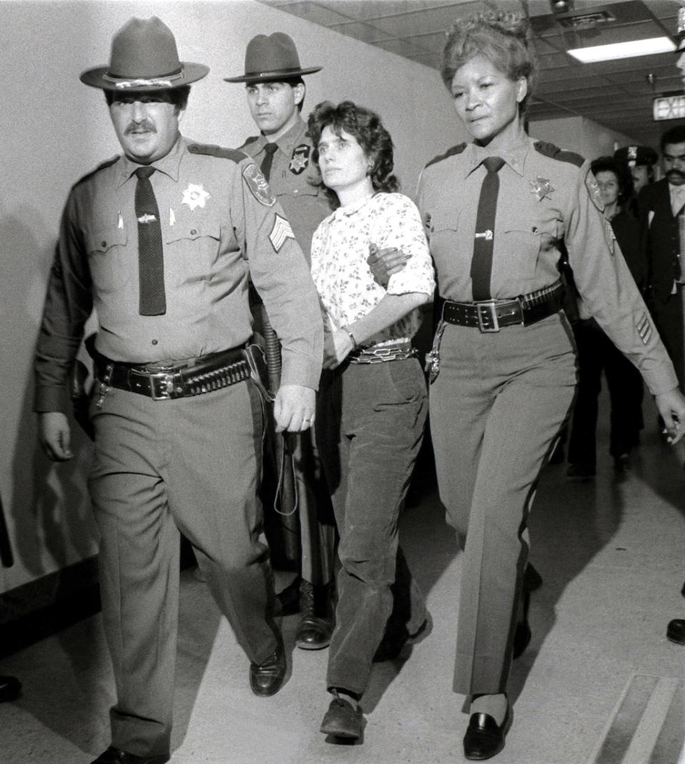 FILE - In this Nov. 21, 1981 file photo, Weather Underground member Katherine Boudin is led from Rockland County Courthouse in New City, New York, by sheriff's officers. Boudin, a former member of the radical Weather Underground who spent more than two decades in prison for her role in a fatal 1981 armored truck robbery and then spent decades helping other inmates, has died Sunday, May 1, 2022 at age 78. (AP Photo/Handschuh, File)