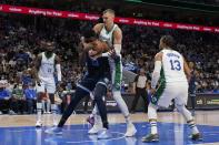 Dallas Mavericks' Tim Hardaway Jr. (11) and Jalen Brunson (13) look on as center Kristaps Porzingis, center rear, and Memphis Grizzlies forward Jaren Jackson Jr. (13) wrestle for control of a rebound in the first half of an NBA basketball game in Dallas, Sunday, Jan. 23, 2022. (AP Photo/Tony Gutierrez)