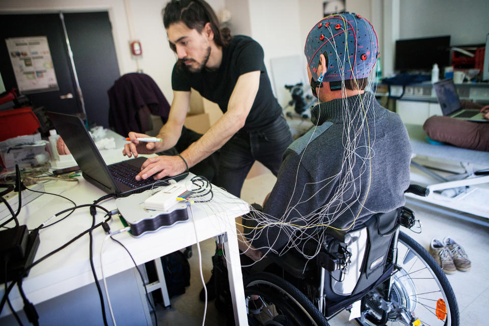 The first Cybathlon will be held in Switzerland in October 2016. It is a competition for athletes equipped with bionic devices (robotized prosthetic legs and arms, motorized wheelchairs, exoskeletons, bikes using electrical muscle stimulation and brain-computer interface races). This competition helps raise public awareness on the evolution of work on robotic assistive technology and strengthens exchanges between research teams. Among the French teams is ENS Lyon. This team will take part in the cycle race, with a bike that has electrical muscle stimulation, as well as the brain-computer interface race during which tetraplegic athletes steer their avatar during virtual races using brain signals. The team leader, Vince, will be one of the pilots. He has been tetraplegic since a bike accident, and is a physics researcher. He changed his research to technology, which can help handicapped people in their daily lives. He is training for the brain computer interface race with Amine, a postdoc researcher in physics. He is wearing an EEG helmet which enables his neuronal activity to be tracked. The team has to determine the signals that are the most perceptible and isolatable on the EEG so that a computer action can be attributed to an &#xd2;order&#xd3; from the brain. (Photo by: BSIP/Universal Images Group via Getty Images)