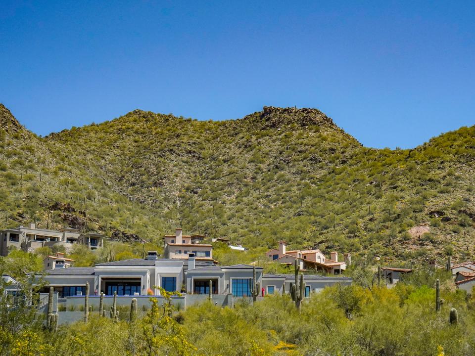 Mansions on a mountain dotted with bushes and cacti