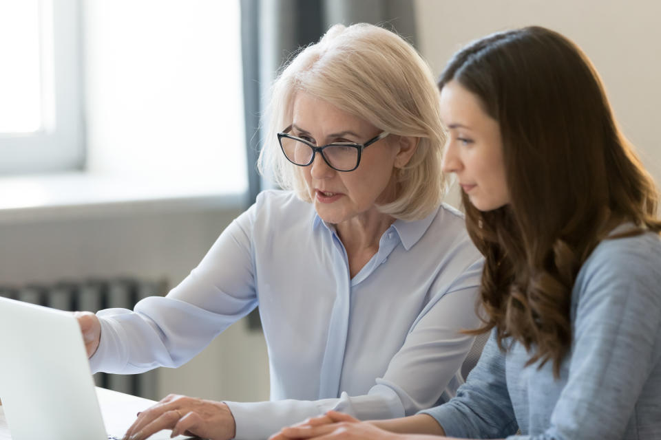 Two women, one older and one younger, looking at a laptop screen together