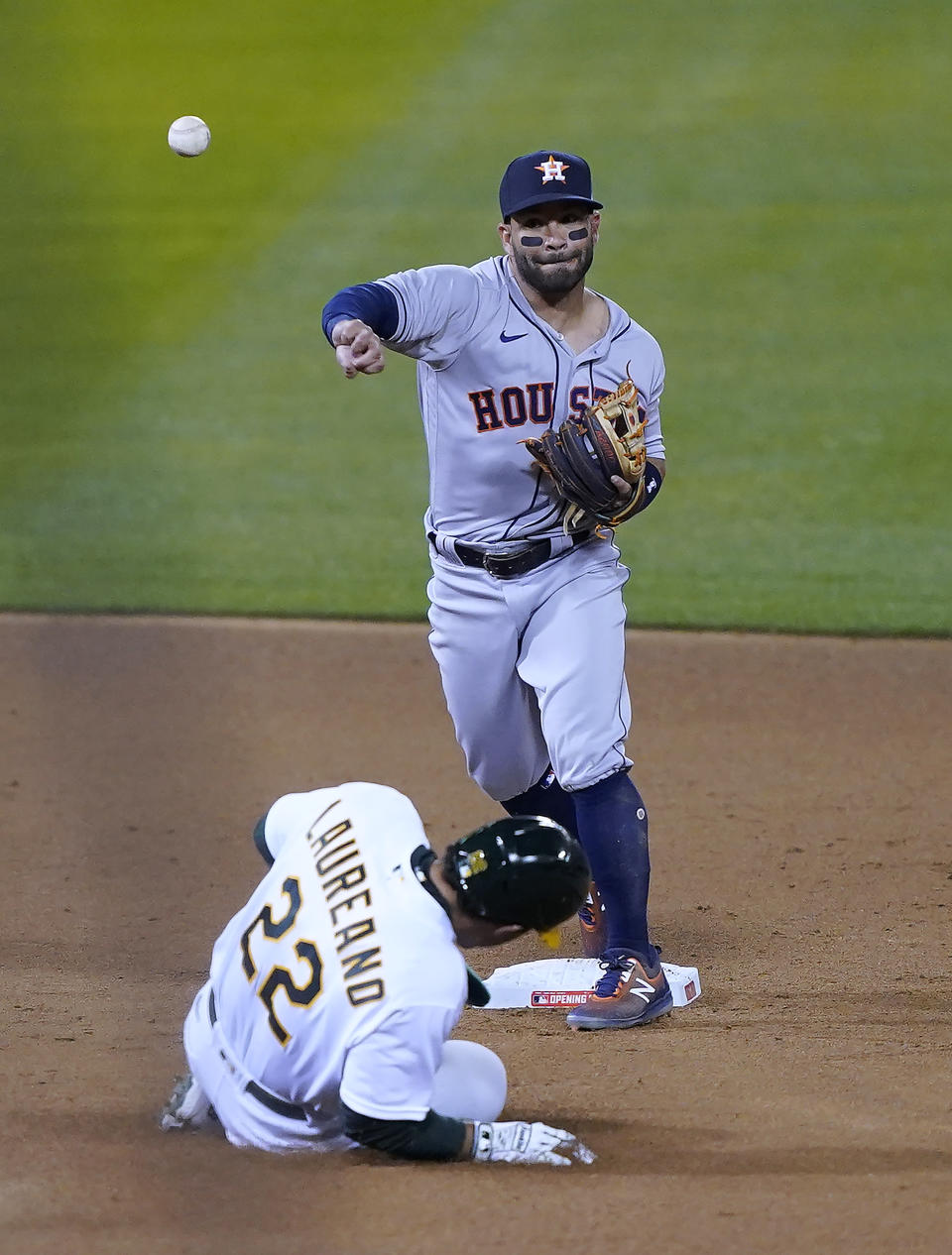 Houston Astros second baseman Jose Altuve (27) throws to first for the double play on a ball hit by Oakland Athletics' Matt Chapman (not shw=own) after forcing Ramon Laureano (22) out at second during the fourth inning of a baseball game in Oakland, Calif., Thursday, April 1, 2021. (AP Photo/Tony Avelar)