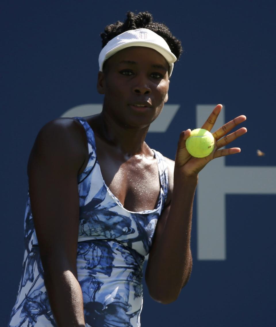 Venus Williams of the U.S. reacts an insect while preparing to serve to Kimiko Date-Krumm of Japan during their match at the 2014 U.S. Open tennis tournament in New York, August 25, 2014. REUTERS/Mike Segar (UNITED STATES - Tags: SPORT TENNIS)