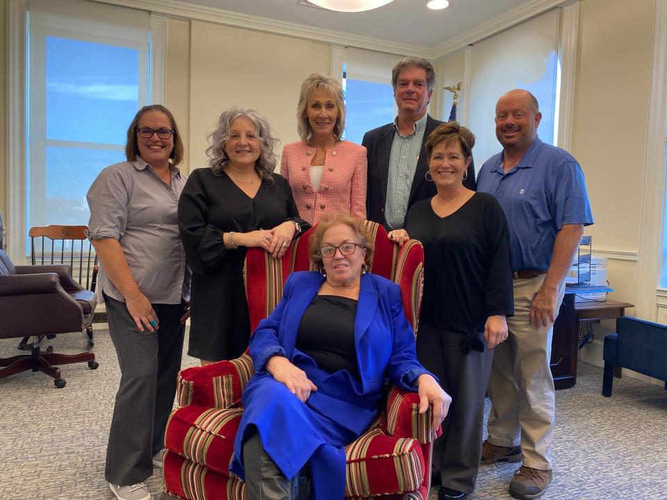 Taunton Christmas Parade 2022 Grand Marshal Helen Cardoso is seated with the mayor and members of the Christmas Parade Committee all around her. From left,  Lisette Miranda; Karen Grossi-Pemberton, Mayor Shaunna O' Connell, George Mendros, Sue Barber and AJ Marshall.